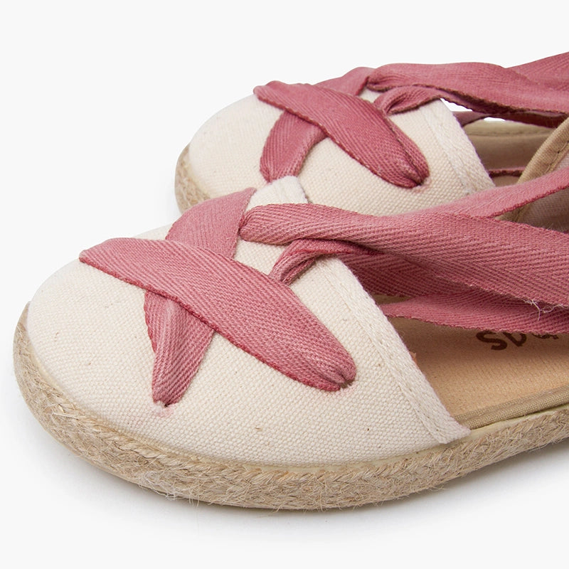 White shoe with pink laces on a white background