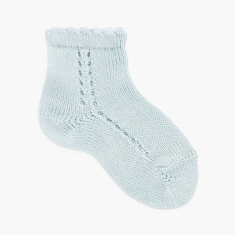 Sage green baby sock on a white background