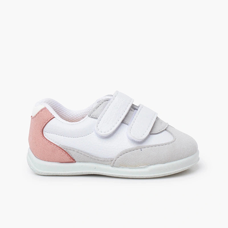 White and pink children's shoe with velcro straps on a white background