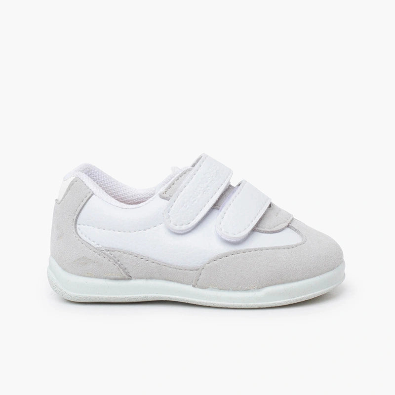 White children's shoe with velcro straps on a white background