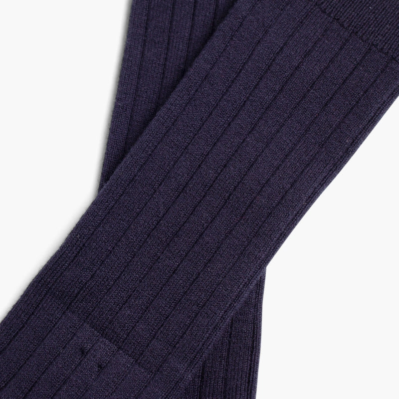 Close-up of a navy blue ribbed sweater on a white background