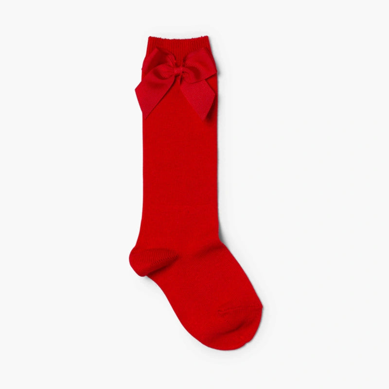 Red knee-high sock with a bow on a white background
