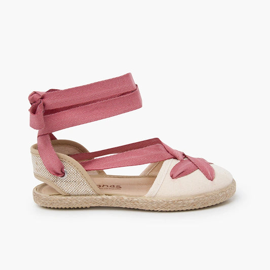 Pink strappy sandal with a white sole on a light gray background
