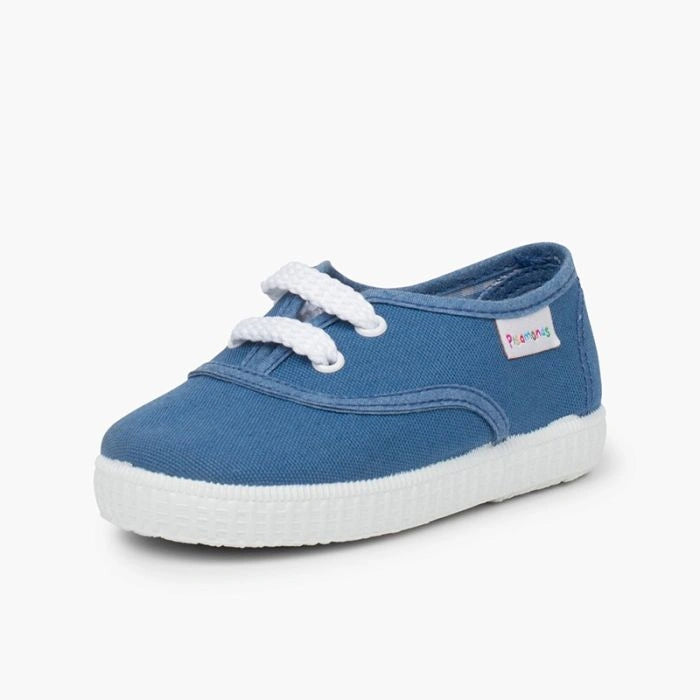 Blue children's shoe with white laces on a light gray background