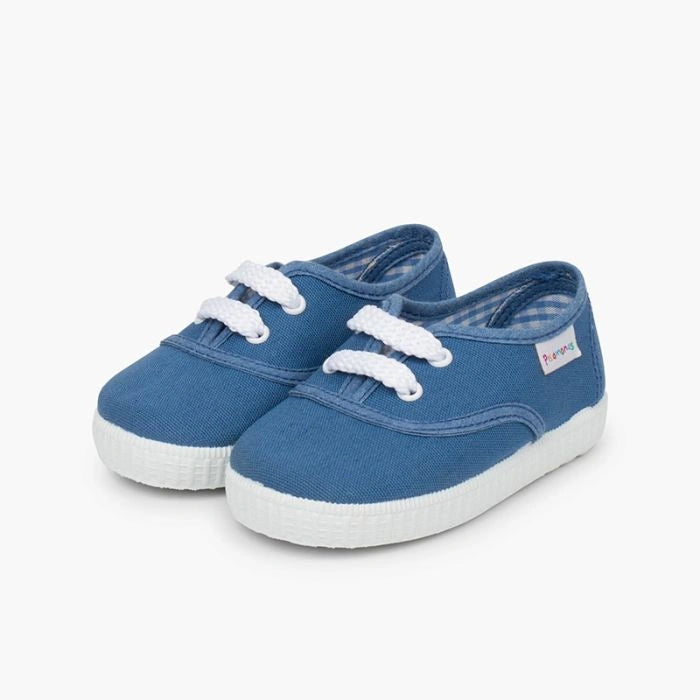 Pair of blue children's shoes with white soles on a white background