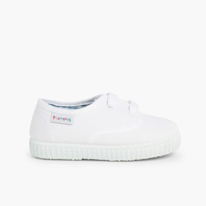 White slip-on shoe with a brand label on a white background
