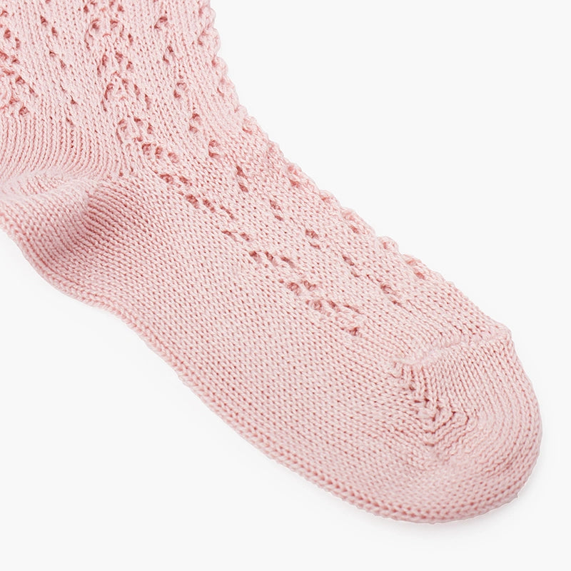 Close-up of a pink knitted sock on a white background