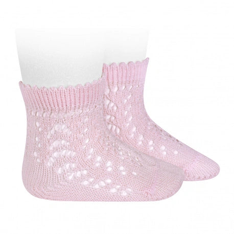 Pink knitted baby socks with openwork pattern on a white background