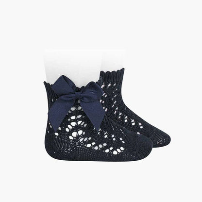 Navy blue crochet socks with a bow on a white background