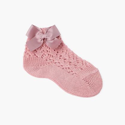 Pink knitted sock with a bow on a white background