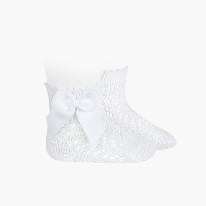 White baby socks with a bow on a white background