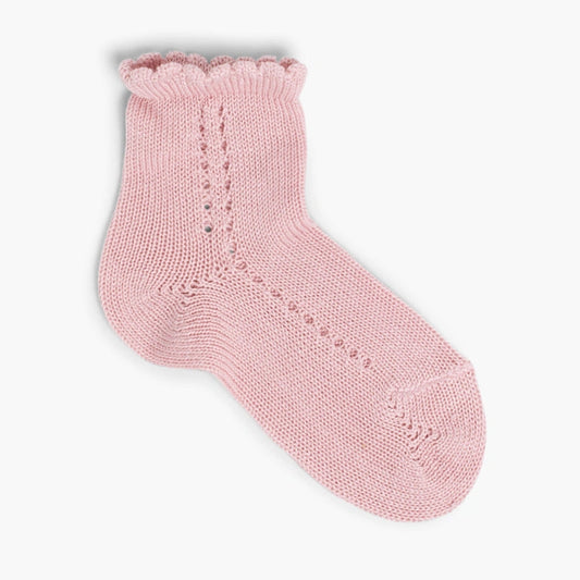 Pink knitted sock on a light pink background