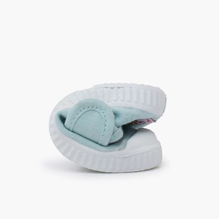 Light blue children's shoe with a white sole on a white background