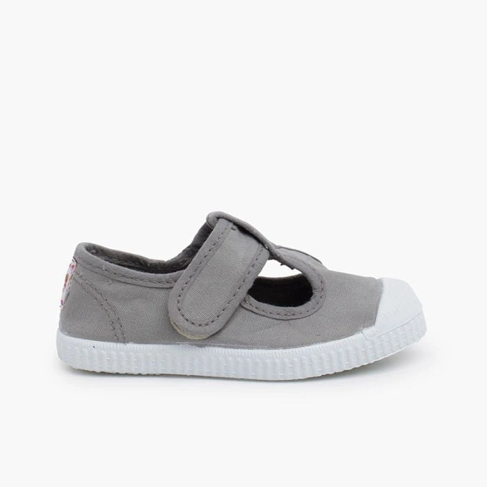 Grey children's shoe with a white sole on a white background