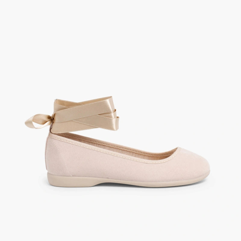 Beige ballet flat shoe with ankle strap on a white background
