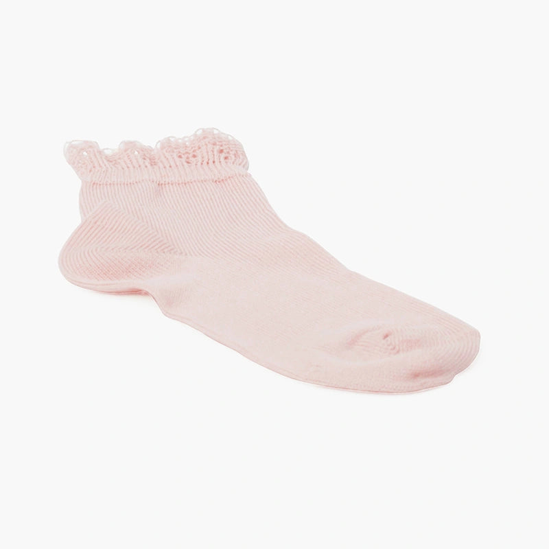 Pink baby sock with ruffled top on a white background