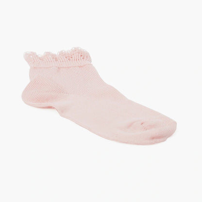 Pink baby sock with ruffled top on a white background